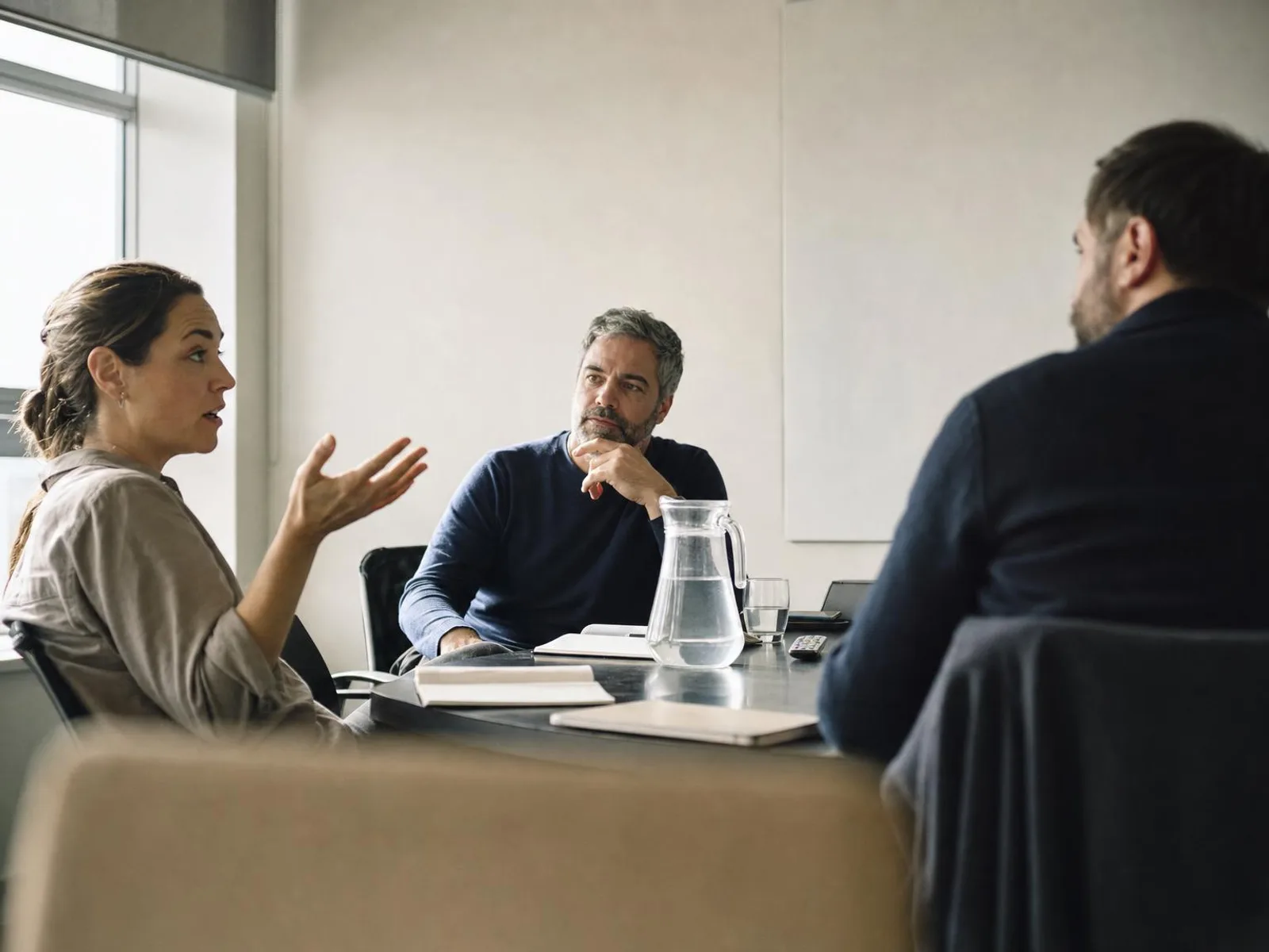 Dans une salle de réunion ordinaire, deux personnes se font face de part et d'autre d'une table, l'une suspendue au milieu d'une phrase, l'autre acquiesçant poliment.