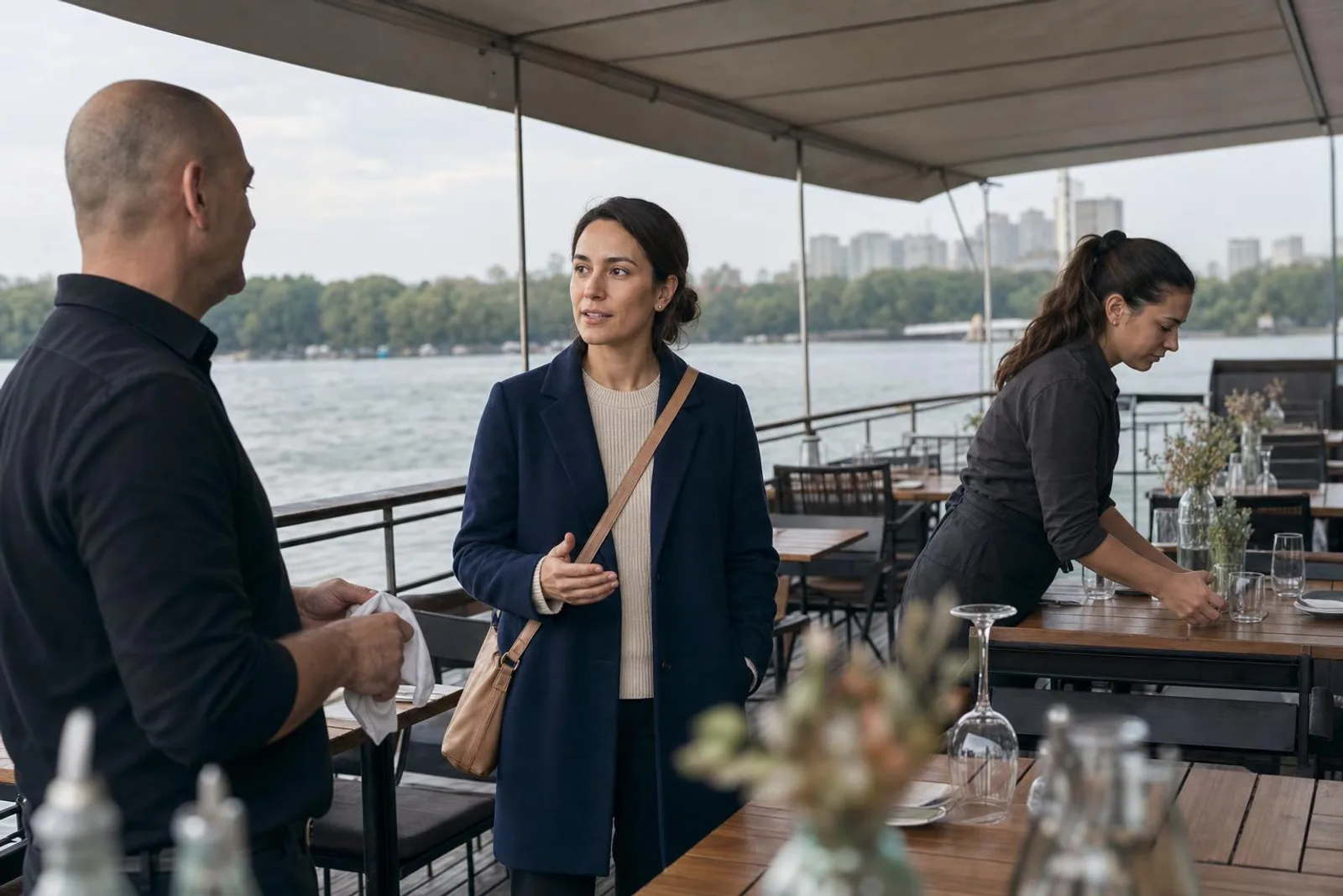 Sur le pont d'une péniche-restaurant, une passante converse avec le responsable de salle.